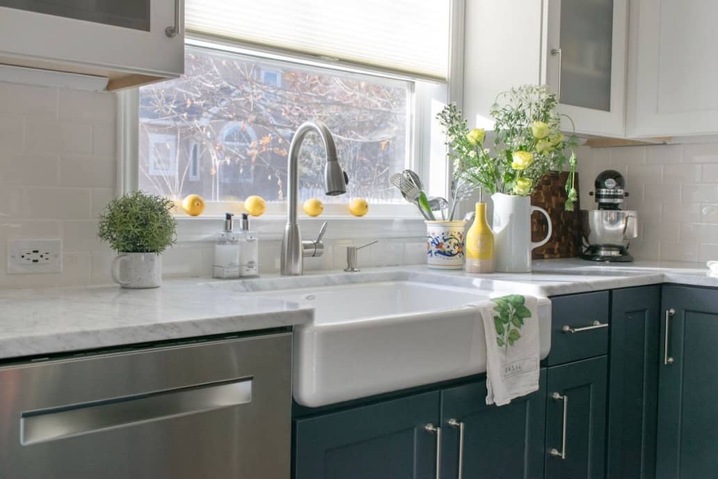 Farmhouse sink in classic kitchen remodel with carrara marble kitchen counters