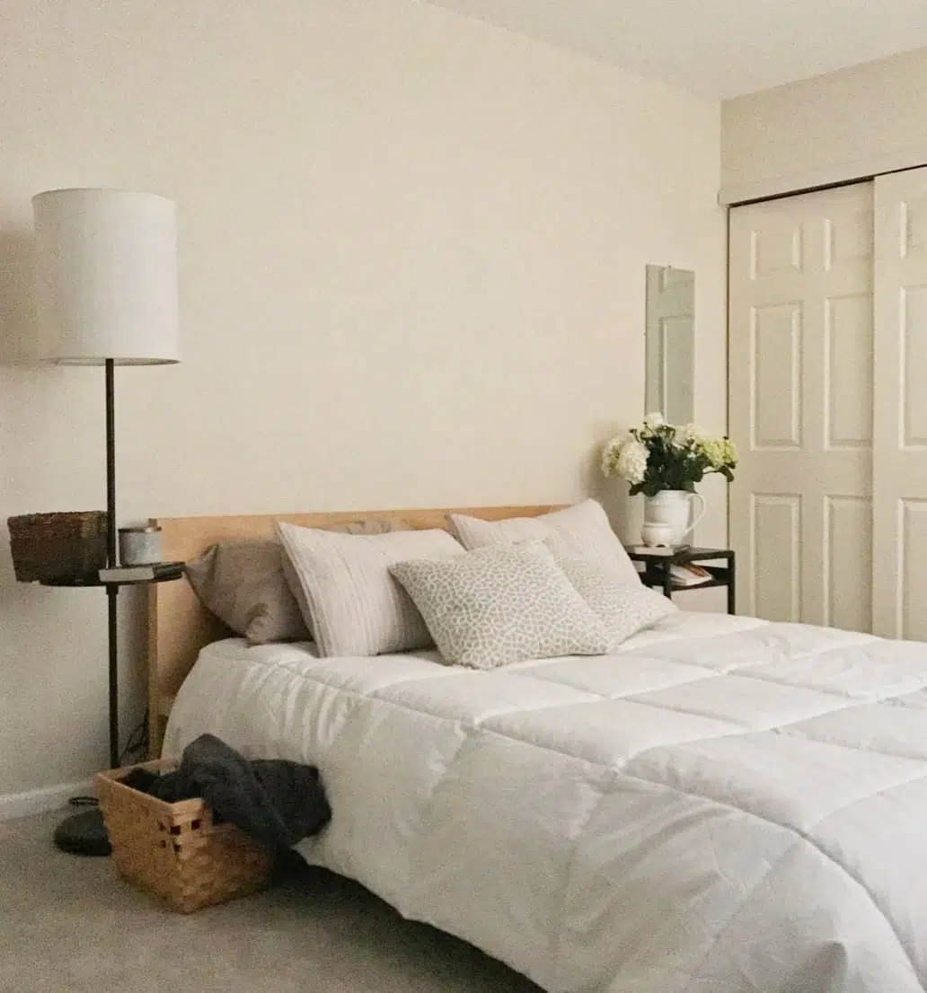 White bed with beige pillows and wood Ikea Malm bedframe