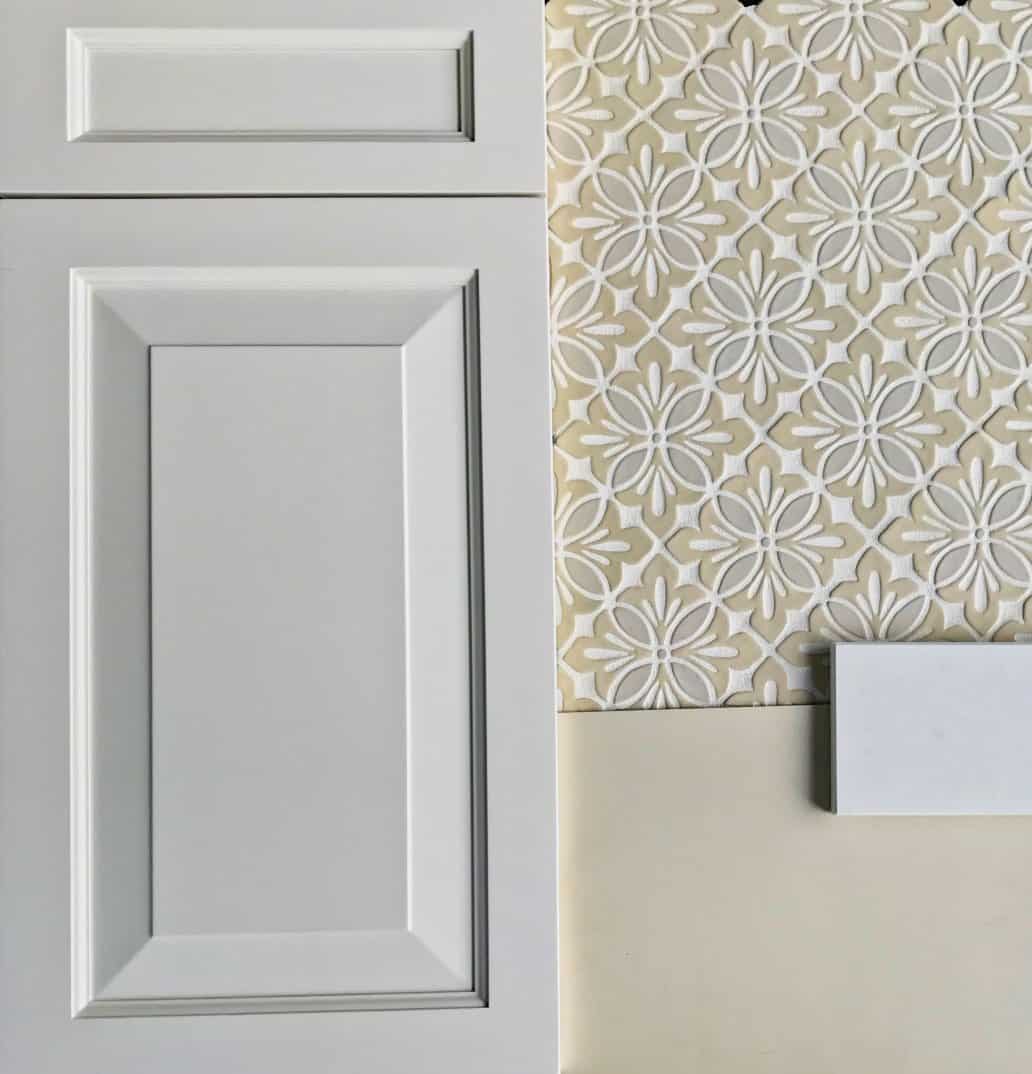White kitchen cabinets with tan mosaic backsplash and white quartz counters.