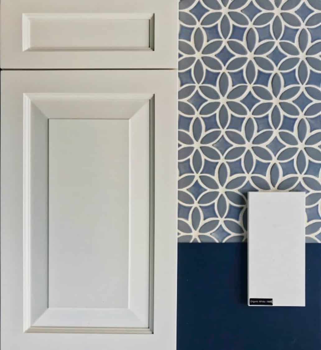 White kitchen cabinets with blue mosaic backsplash and white quartz counters.