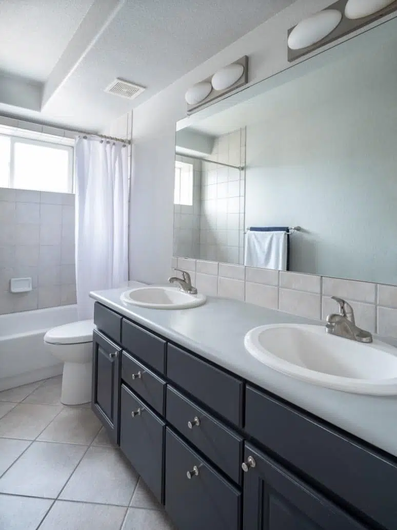 A bathroom with Stonington Gray walls and Witching Hour painted bathroom vanity