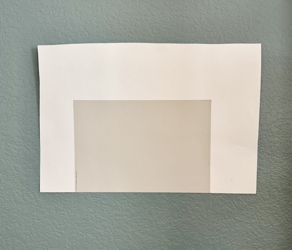 A swatch of paint is placed on a white poster board while testing paint colors.