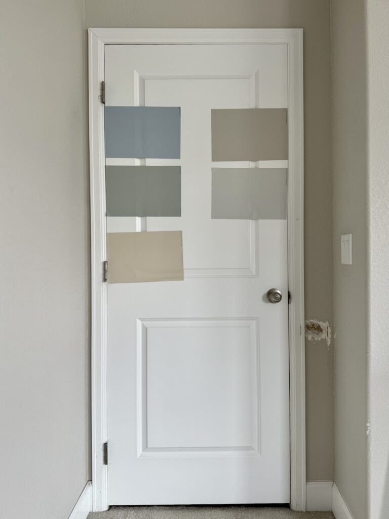 An example of the correct way to test interior paint colors by placing paint samples on a white door.