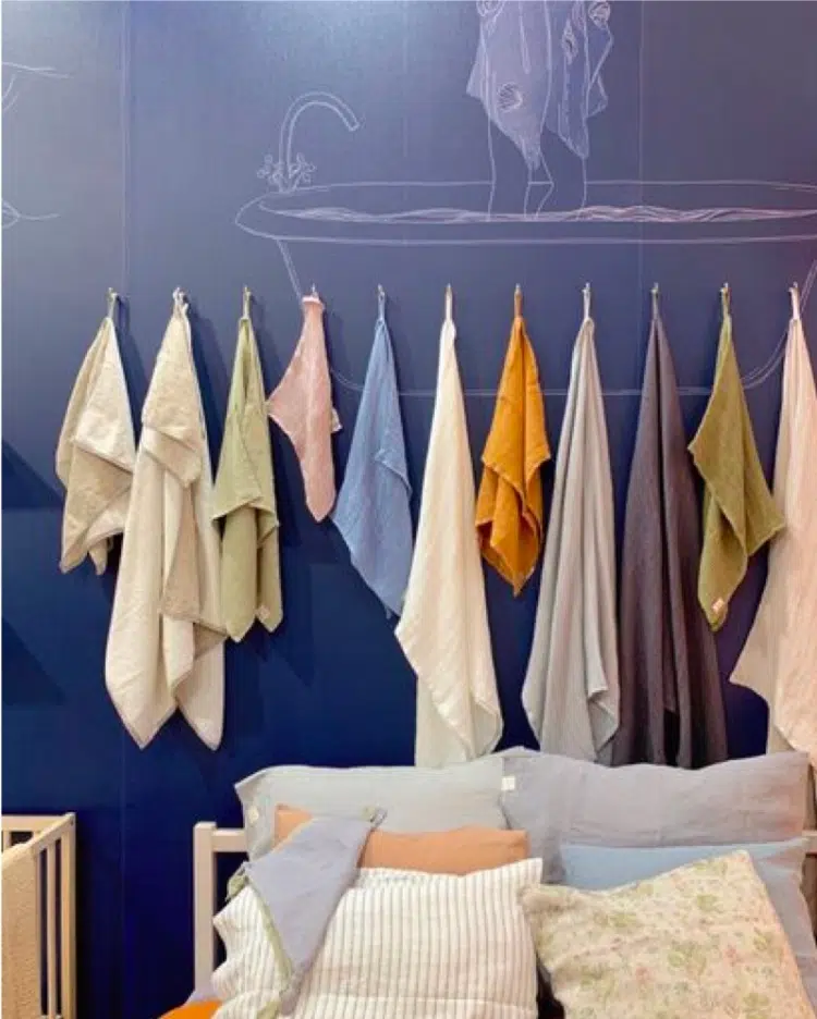 Bed with colorful linens and hanging colorful towels from Maison d'Objet predict paint color trends