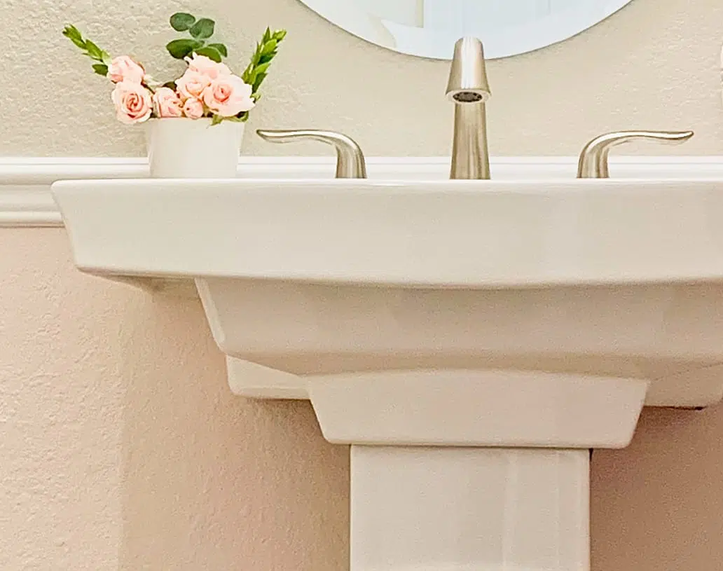 BM First Light pink paint is paired with SW Agreeable Gray paint in a pink and gray powder room