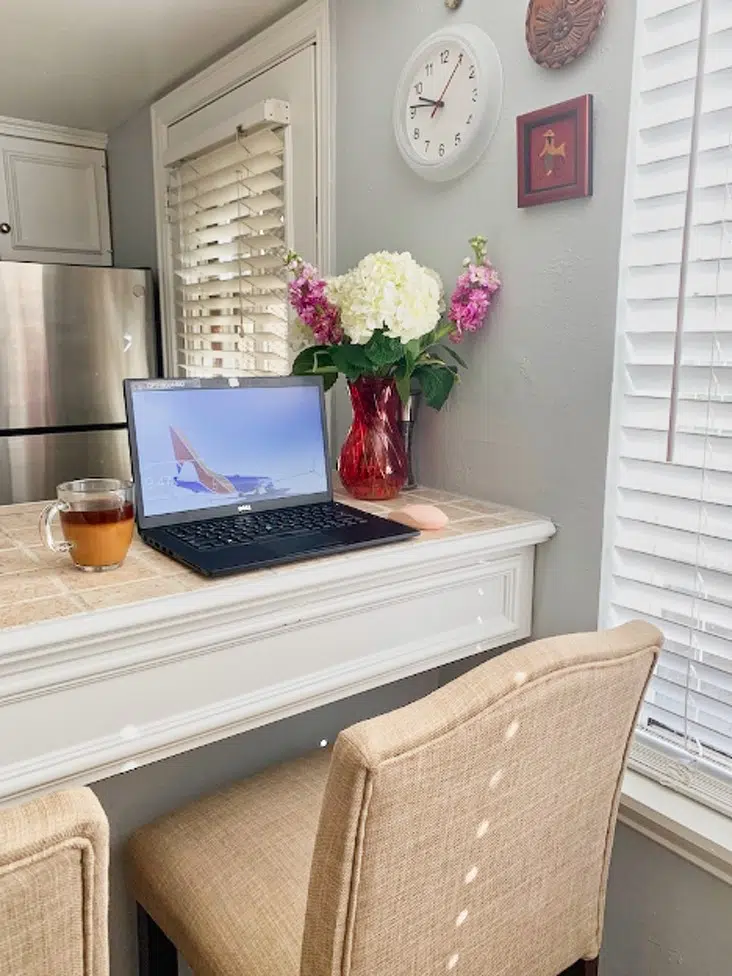 Home office in kitchen counter with laptop and Benjamin Moore Shoreline walls.