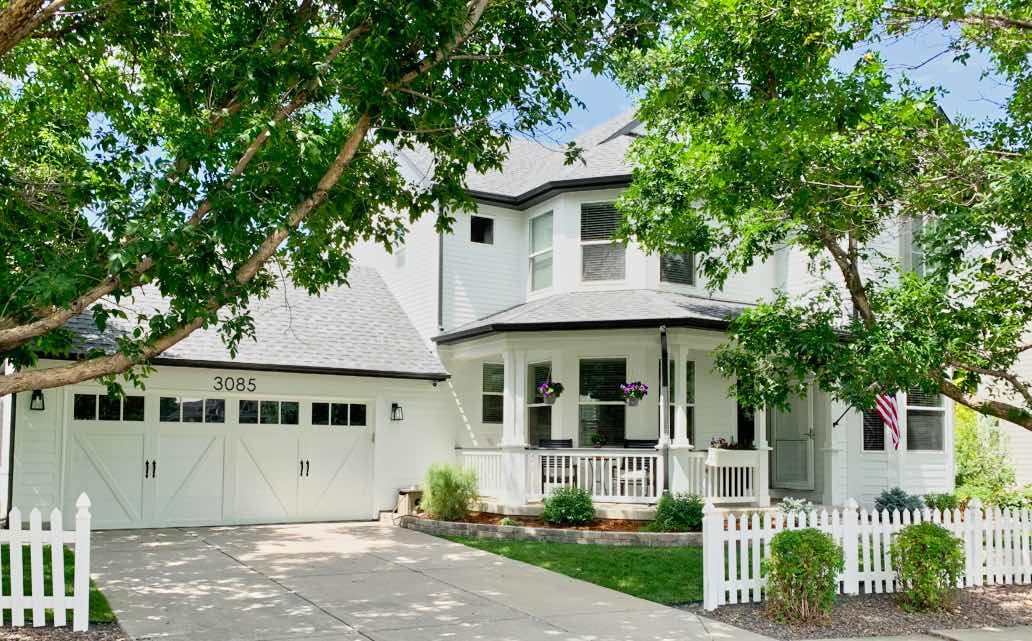 Simple two-story white house with wooden door, windows, and porch