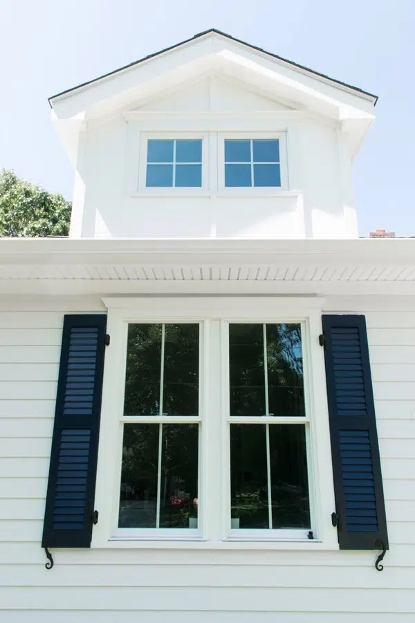 White farmhouse window with blue shutters