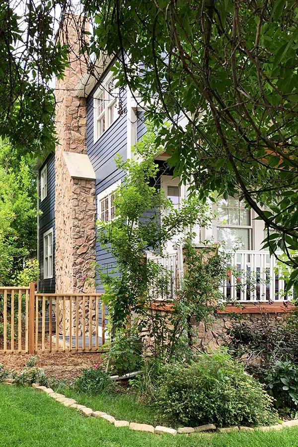 Blue house with red stone chimney and white trim