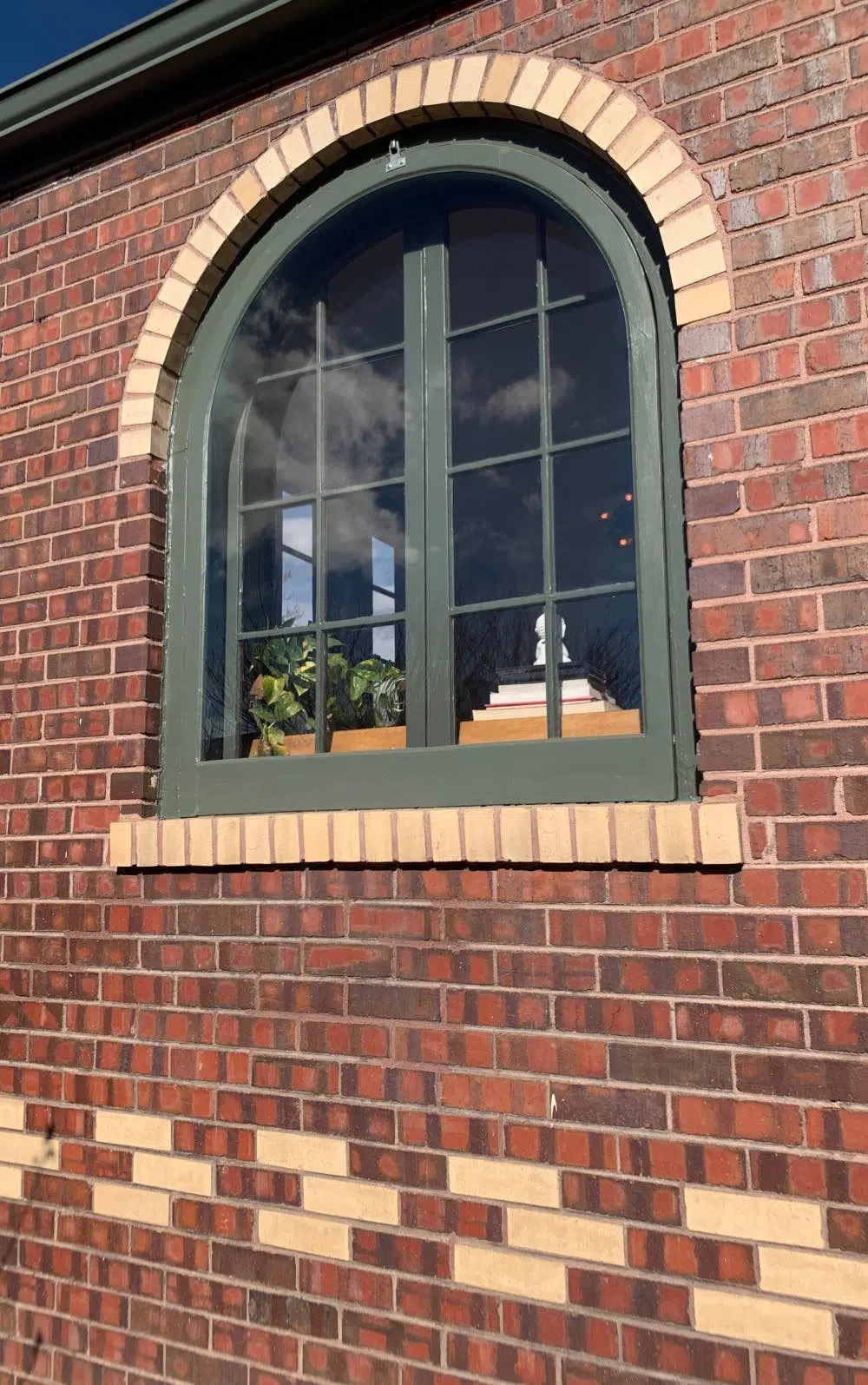 Red brick cottage with green roof and SW Pewter Green paint