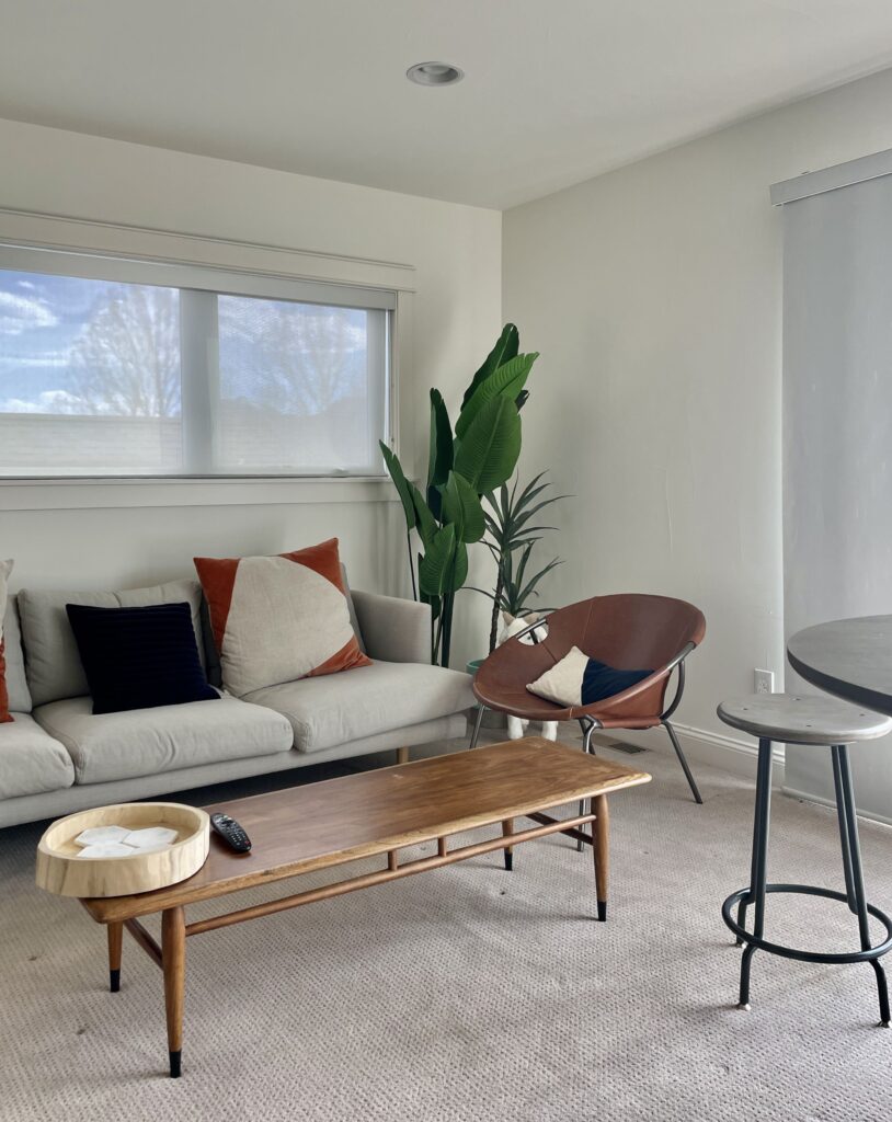 A bachelor pad living room is painted with Benjamin Moore Cloud White paint.