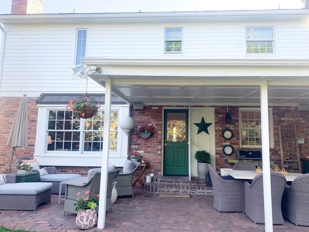 Backyard red brick patio and house with white paint