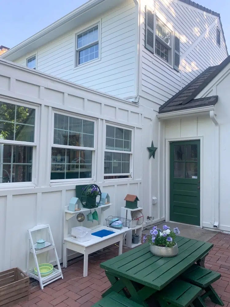 Red brick patio with SW Greek Villa siding and a green back door