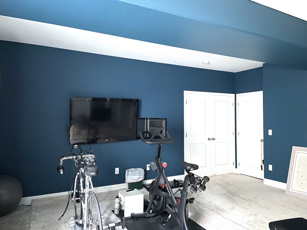 A basement is painted with Benjamin Moore Slate Teal walls. 