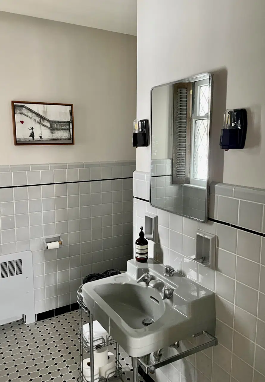 A bathroom with BM Balboa Mist paint and gray tile.