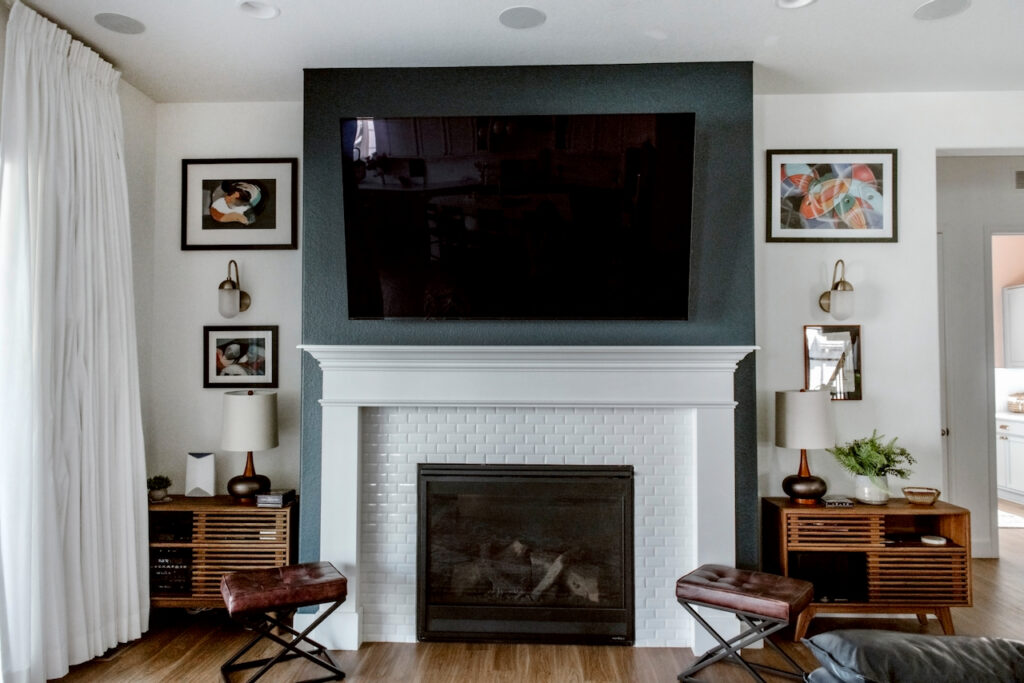 This Hague Blue fireplace helps the large TV disappear into the wall, offering the perfect accent to this otherwise light living room.