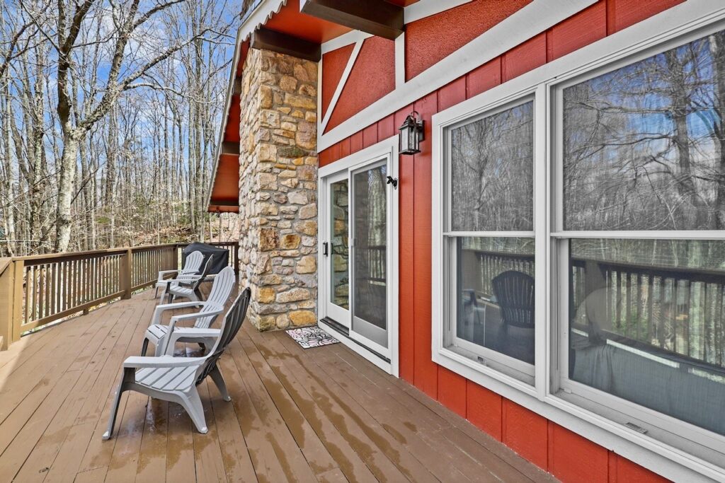 A back deck looks brand new next to the home exterior painted with Sherwin-Williams Rustic Red paint.