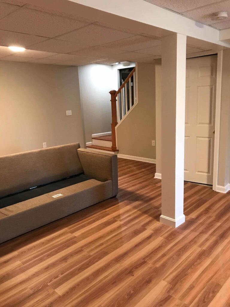 A basement living room painted with BM Edgecomb Gray wall paint.