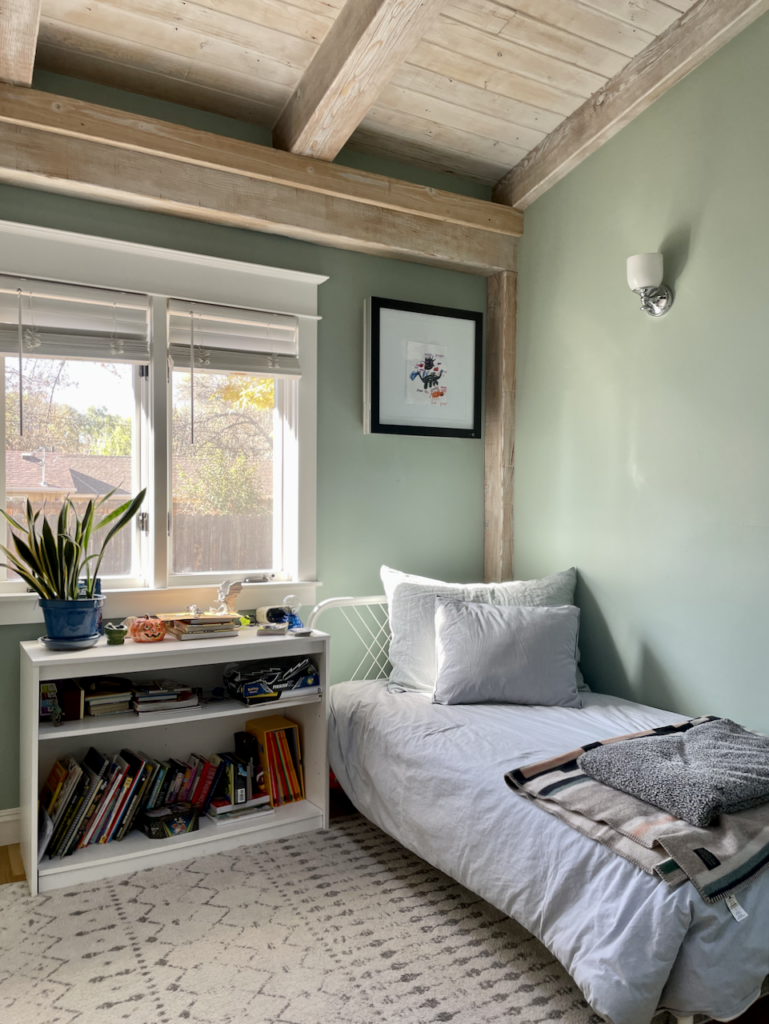 A boy's bedroom features a wood ceiling and Green-Blue Farrow & Ball paint, a beautiful addition to a whole house color palette.
