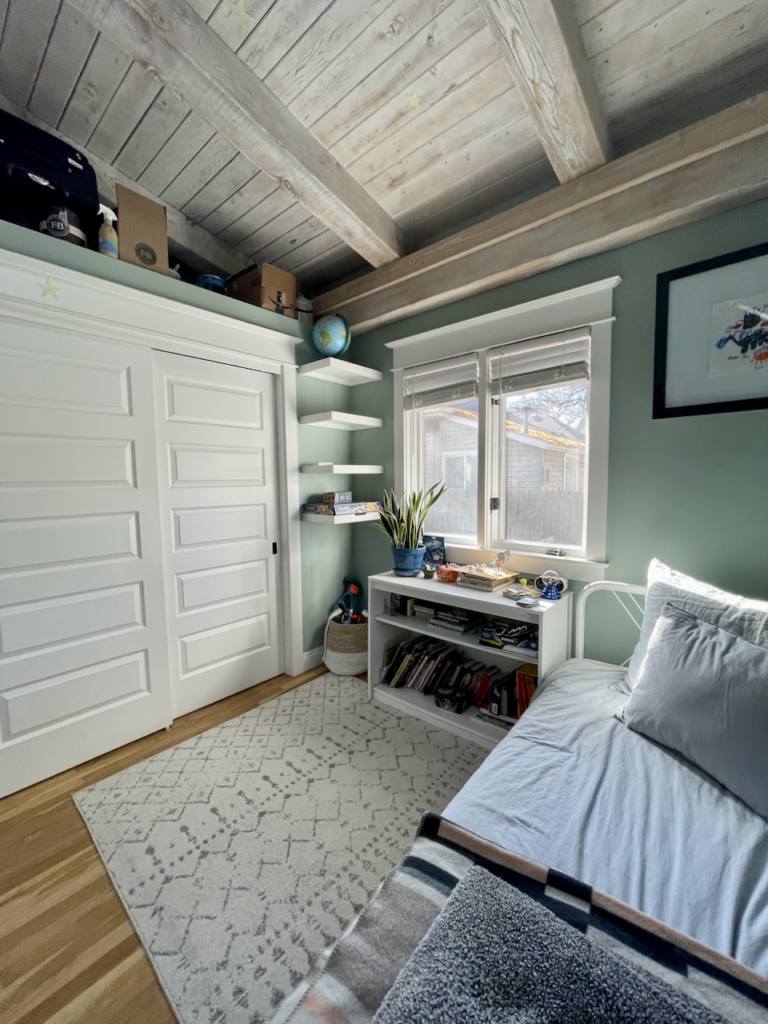 A boys' bedroom with white closet doors and Green Blue paint on the walls