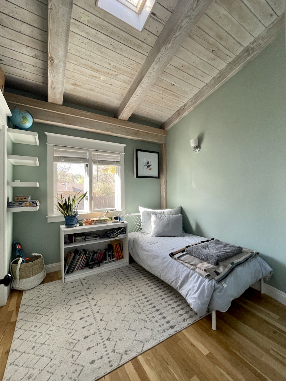 A small bedroom painted with Green Blue by Farrow & Ball with a wood ceiling