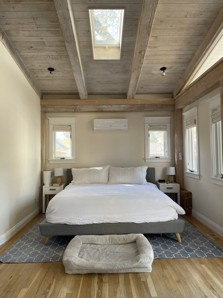A master bedroom with wood ceiling painted in Panda White paint.