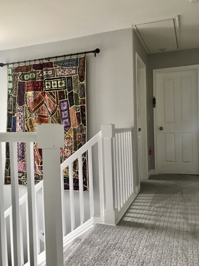 Stonington Gray hallway with a colorful wall tapestry