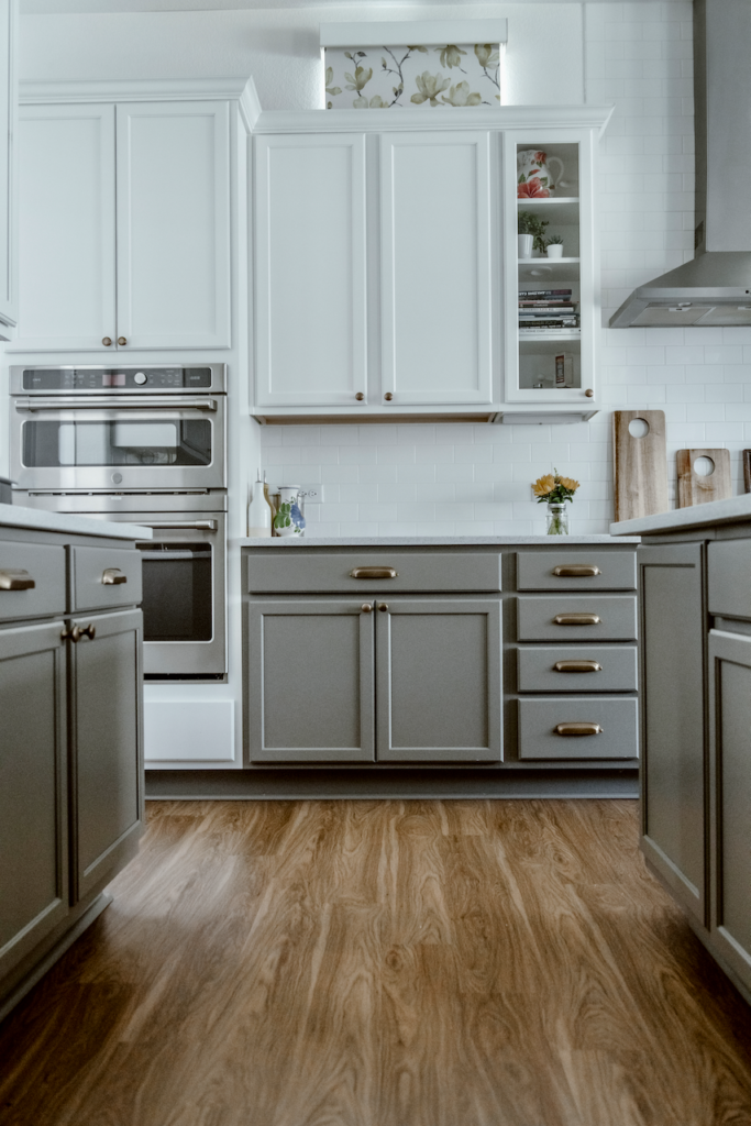 White and gray kitchen cabinets with warm LVP flooring