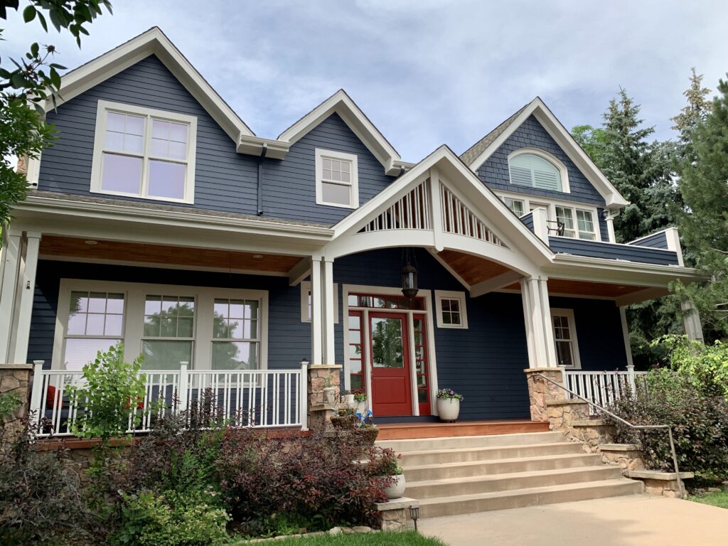 A house with BM Hale Navy siding, BM Pale Oak trim & BM Caliente front door