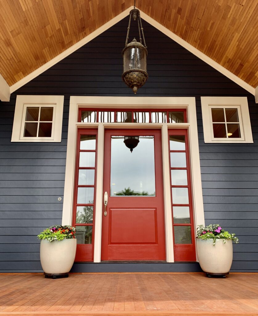 An entryway painted with Benjamin Moore Hale Navy exterior paint and Caliente paint