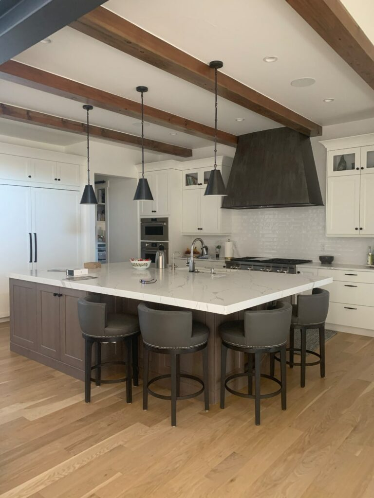 Simply White kitchen cabinets in farmhouse kitchen with Rift oak island cabinets.