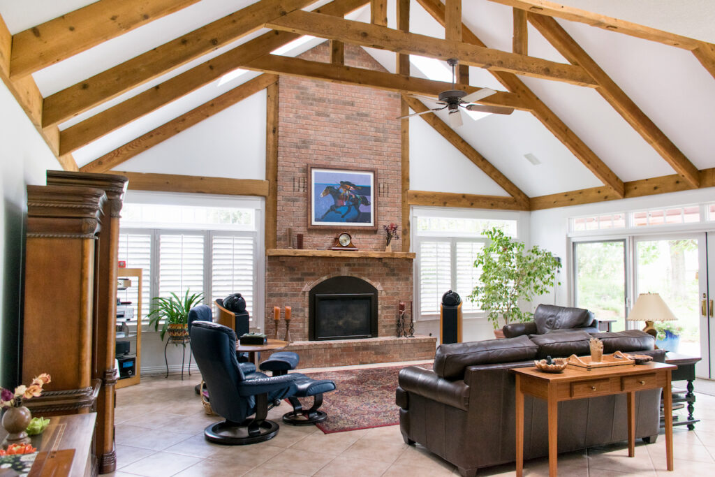 A family room with wood beams, high ceilings and SW Extra White wall paint