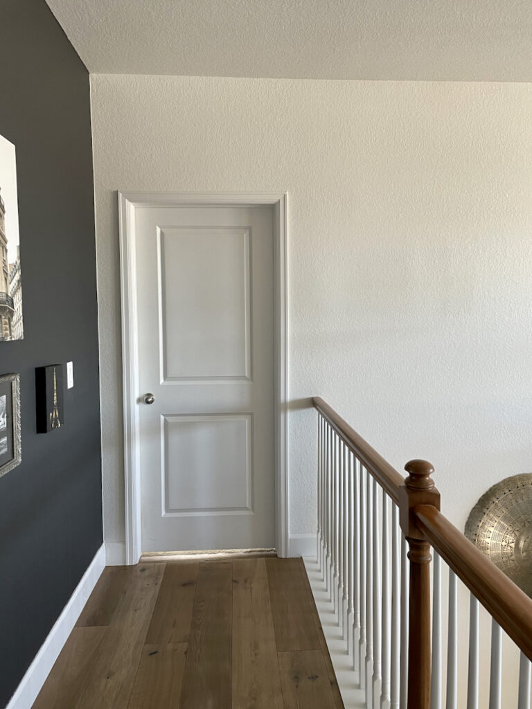 A loft wall is painted with Sherwin-Williams Cheviot, one of the best Sherwin-Williams white paint colors.