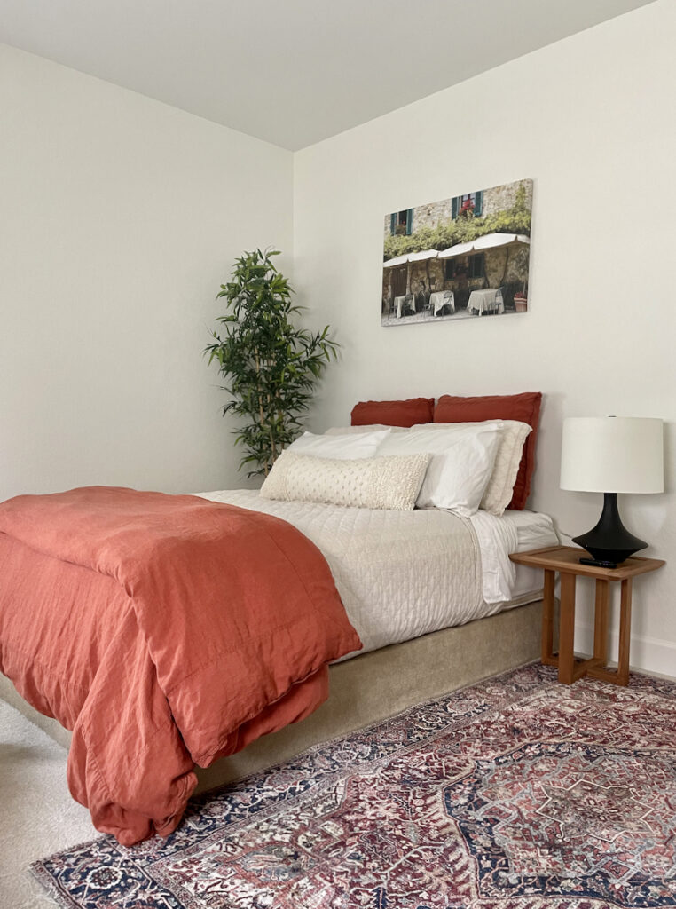 A guest bedroom with Sherwin-Williams Alabaster walls and colorful accents.