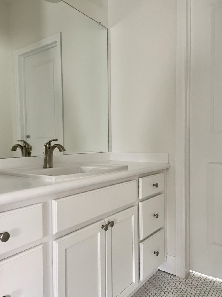A bathroom with SW Alabaster walls and SW Pure White cabinets. 