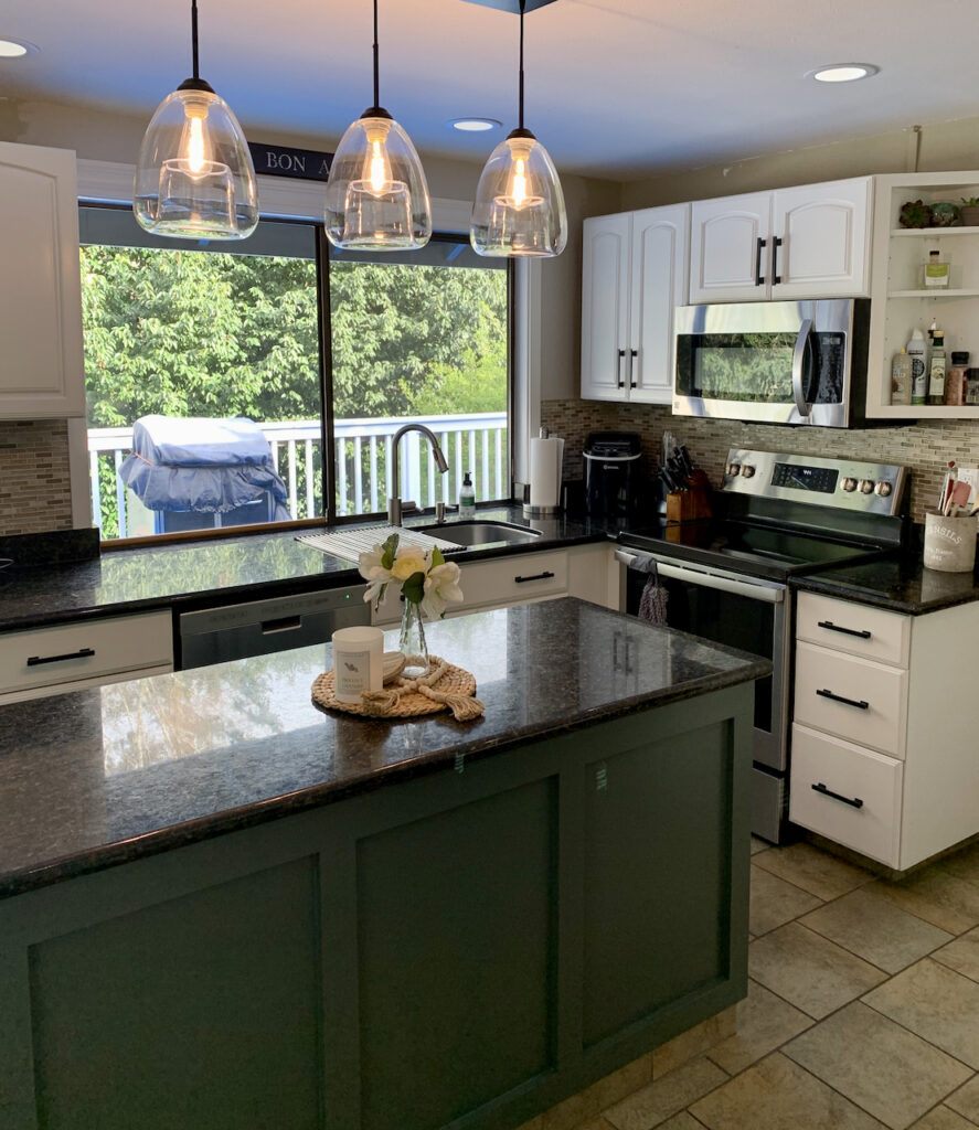 This kitchen features Sherwin-Williams Alabaster cabinets with a green kitchen island. 
