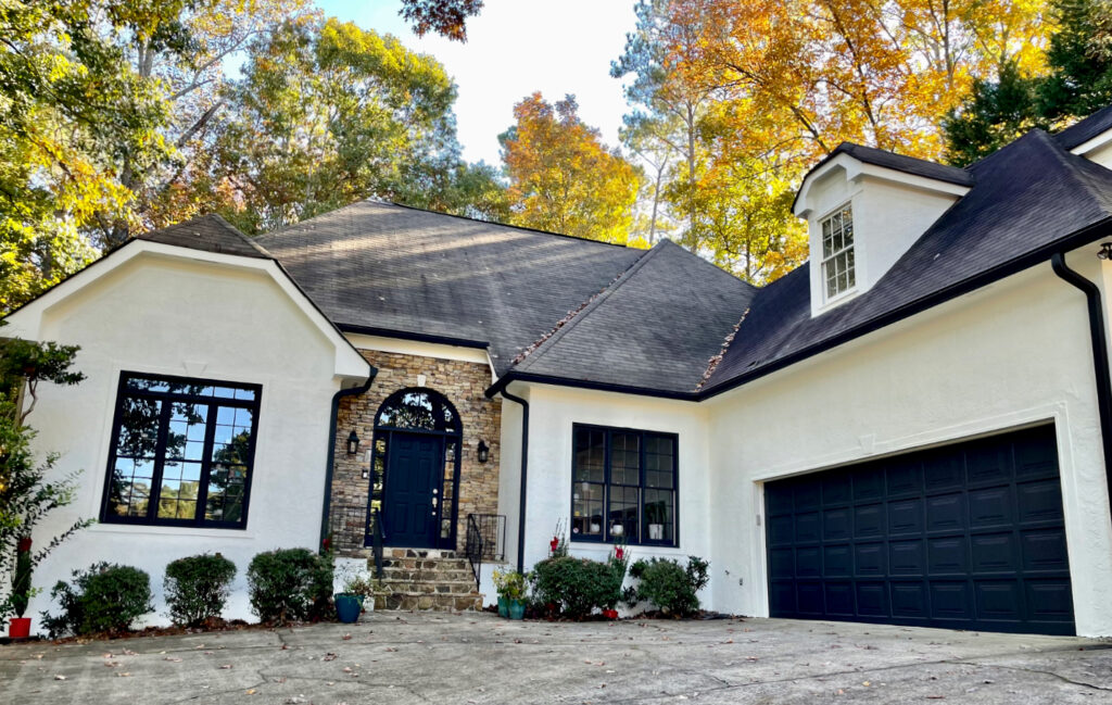 A home painted with Sherwin-Williams Alabaster exterior paint with black trim and brick.