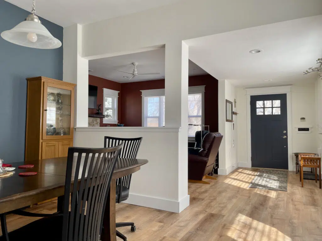 A home features a Benjamin Moore Simply White color palette, including a blue accent wall and Hale Navy front door.