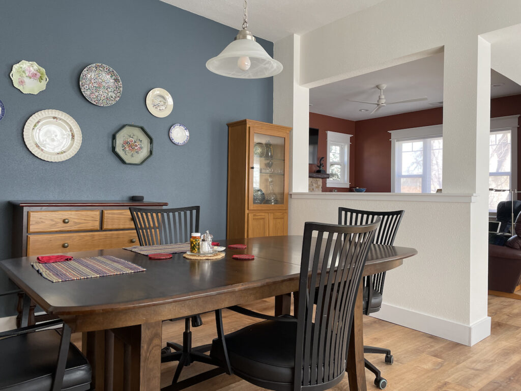 A dining room accent wall is painted with Benjamin Moore Britannia Blue, part of our Simply White color palette.