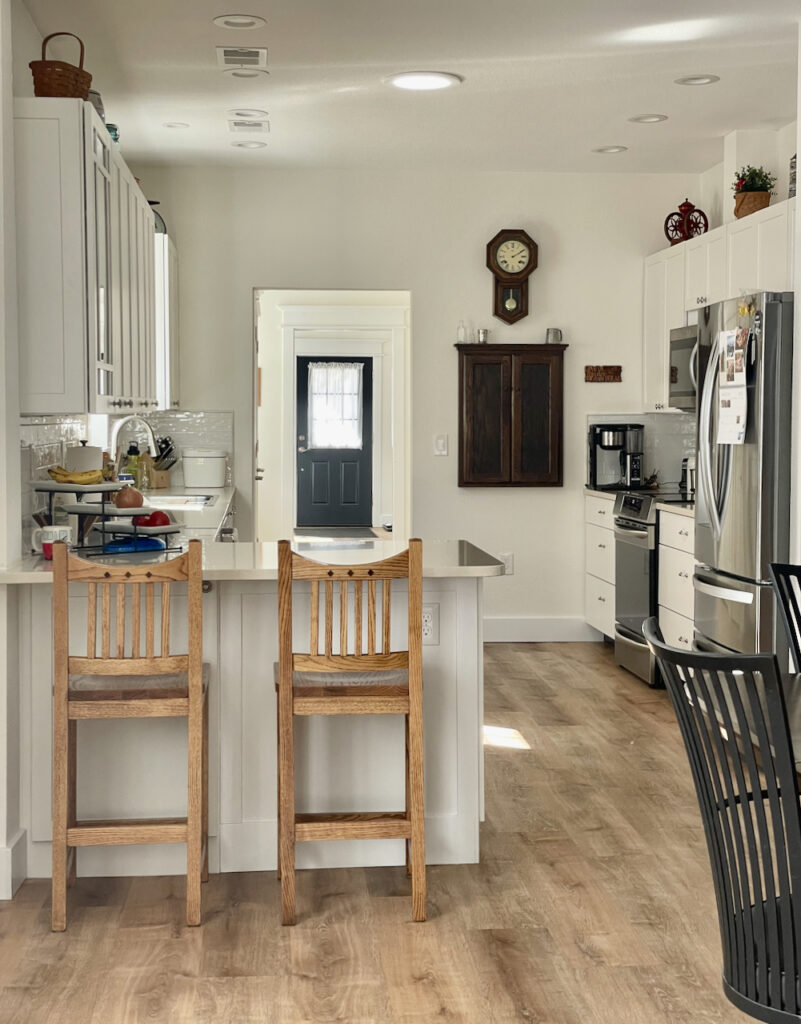 An open concept kitchen is painted with Benjamin Moore Simply White paint.