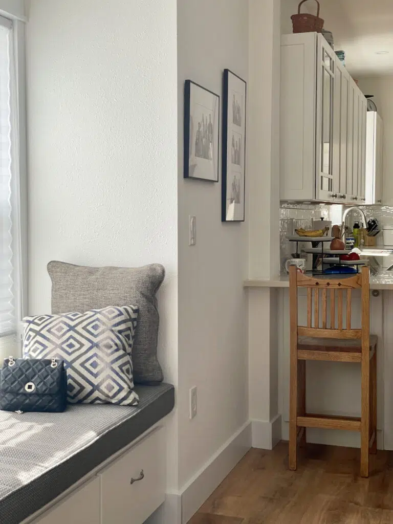 An open concept kitchen and living area are painted with a Benjamin Moore Simply White color palette.