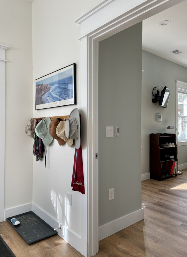 A hallway is painted with Benjamin Moore Simply White paint next to a guest room painted with BM Gray Cashmere.