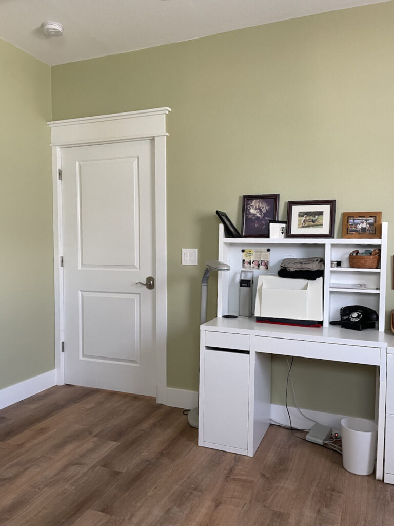 A Benjamin Moore Fernwood Green office provides a colorful accent to the home's Benjamin Moore Simply White color palette.