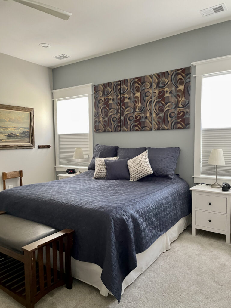A master bedroom features Benjamin Moore Classic Gray paint with a BM Adagio accent wall. 