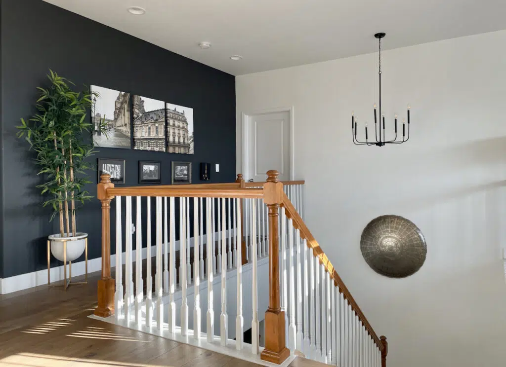 A lofted studio painted with Sherwin-Williams Cheviot paint and an SW Iron Ore accent wall.