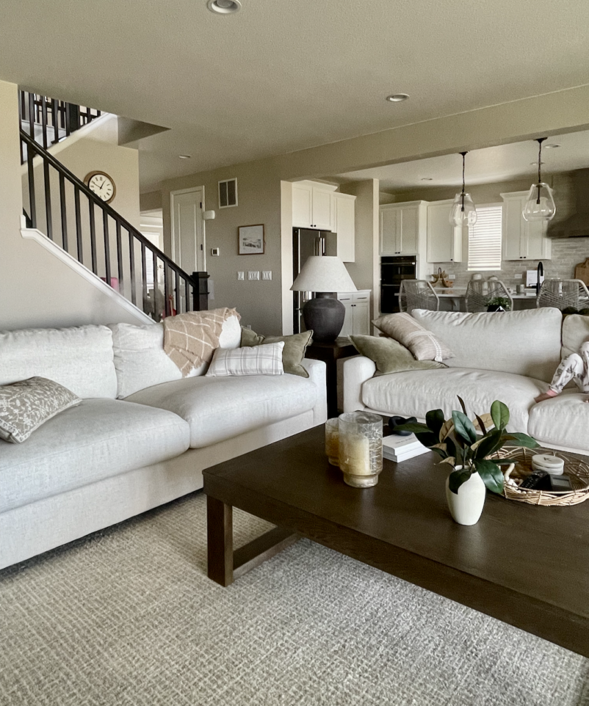 An open-concept living room and kitchen are painted with Sherwin-Williams Accessible Beige. 