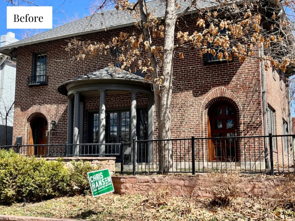 A red brick home with gray trim before painting