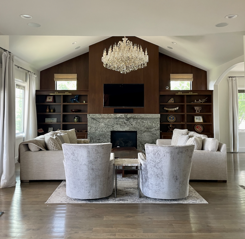 A vaulted ceiling living room with BM Swiss Coffee walls and built-in wood shelves.