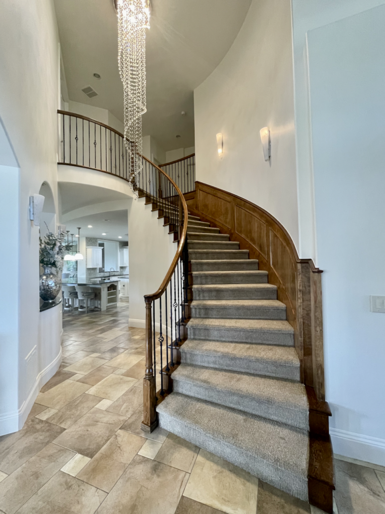 A dark wood staircase painted with BM Swiss Coffee walls. 