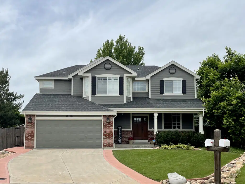 A home is painted with Chelsea Gray exterior paint and features black shutters with white trim.